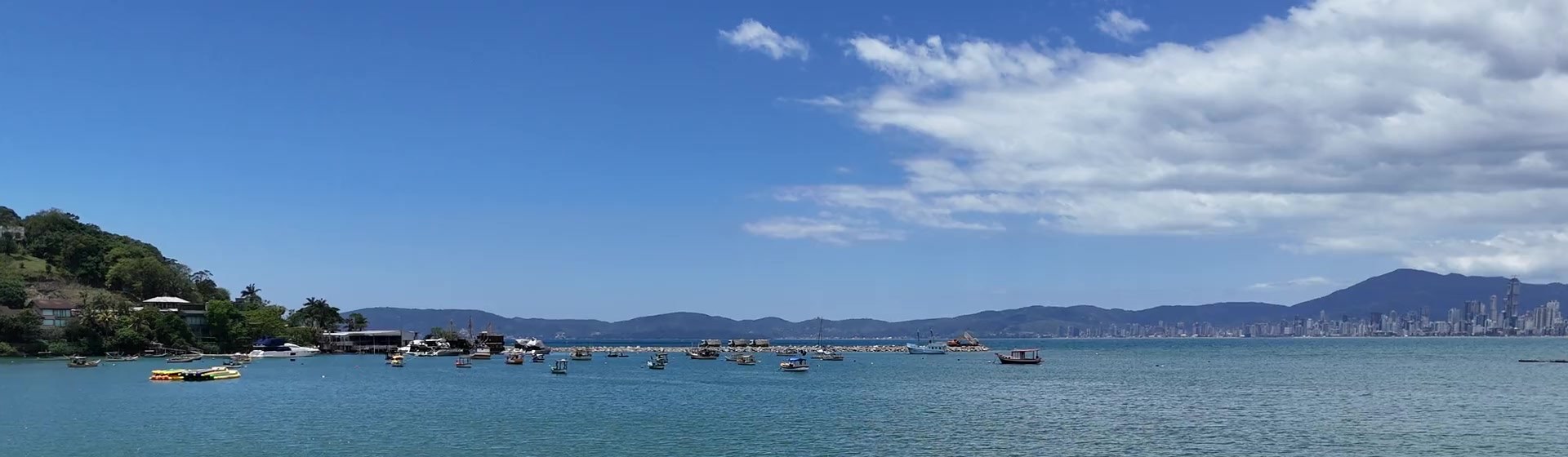 A baía entre Porto Belo e Itapema vista do alto, com barcos de pesca e o skyline no horizonte